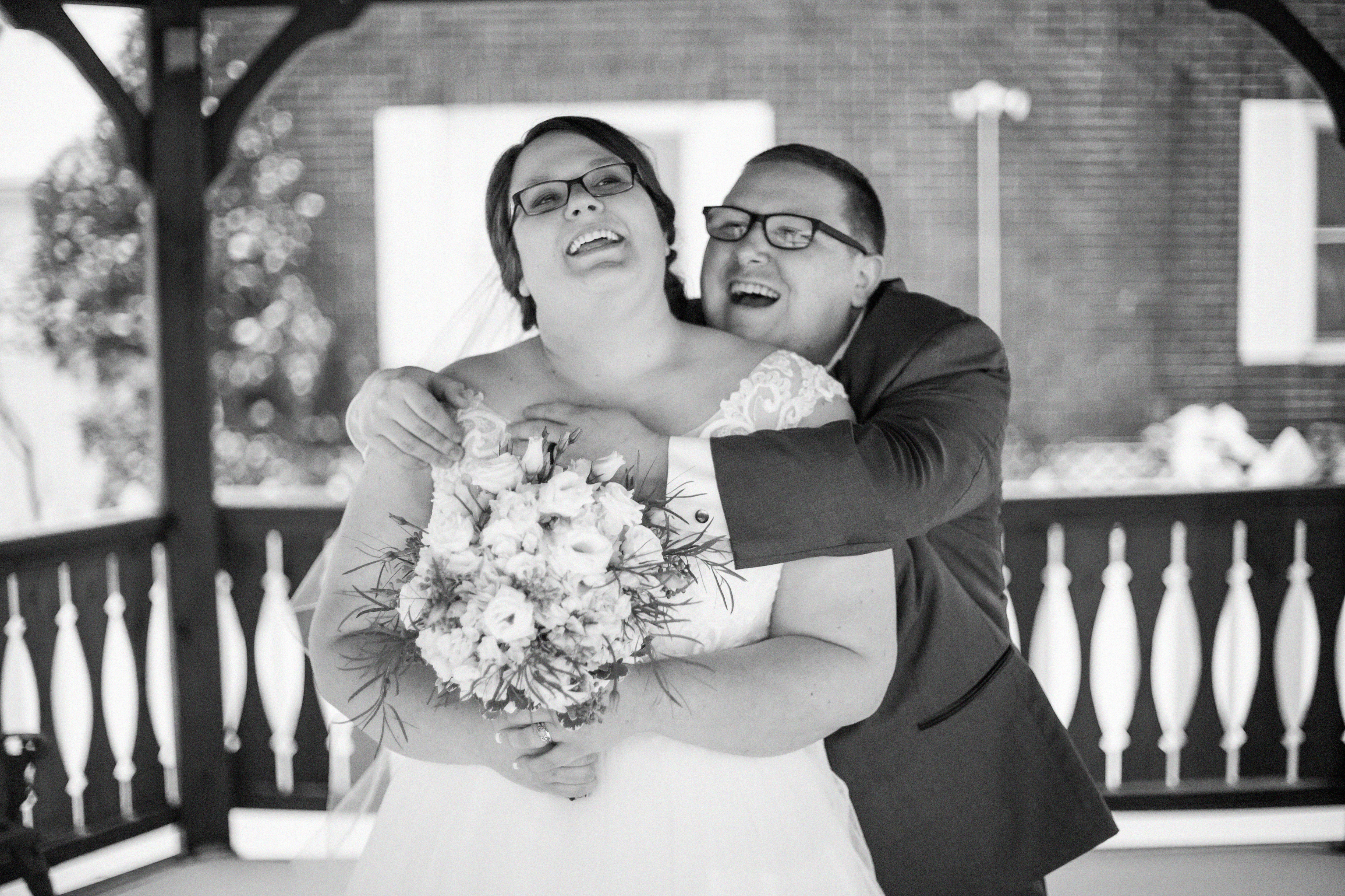 bride and groom laughing inside a gazebo during their winter wedding in Erie, PA