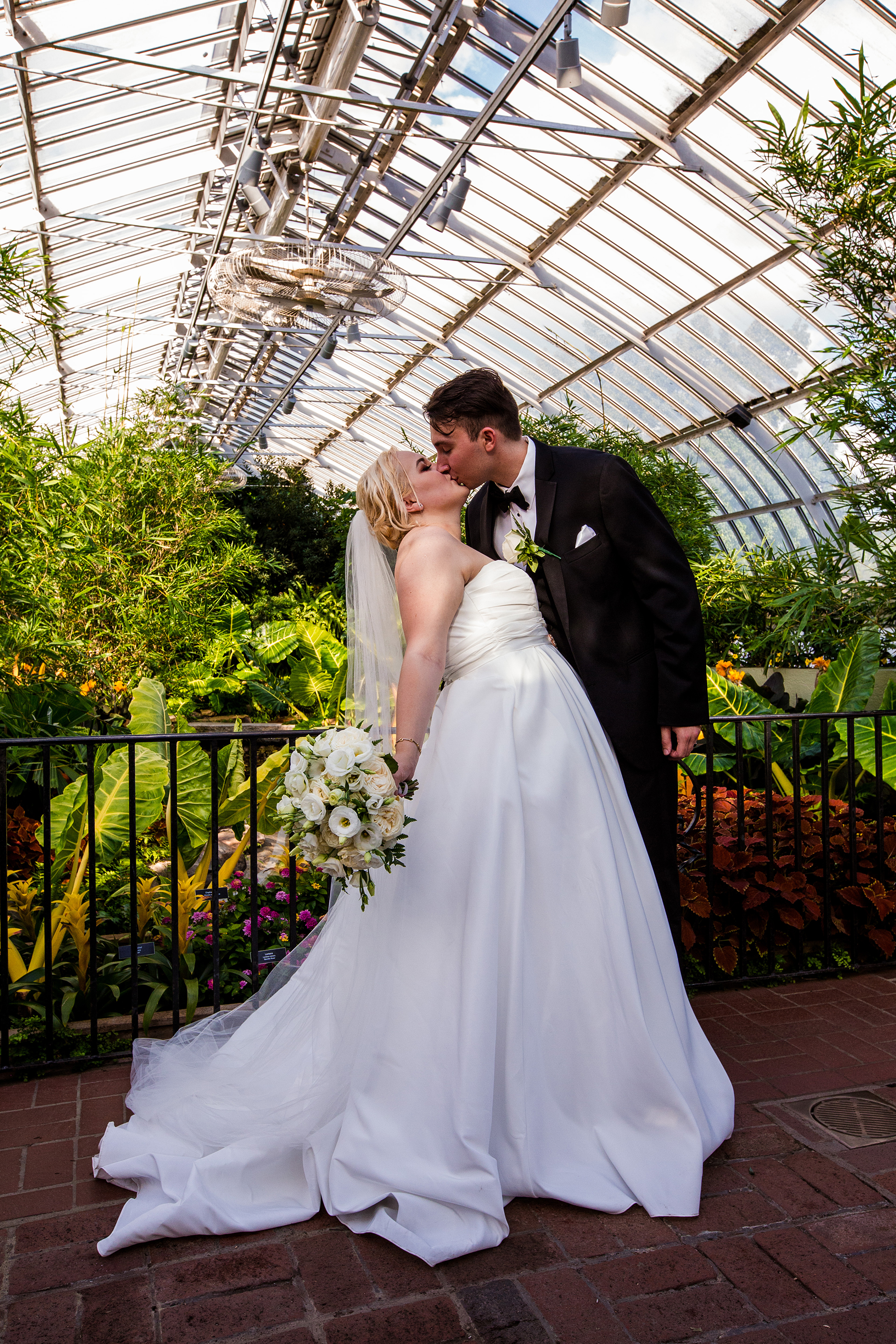 color image of Alexsys and Jon kissing in Phipps conservatory on their wedding day