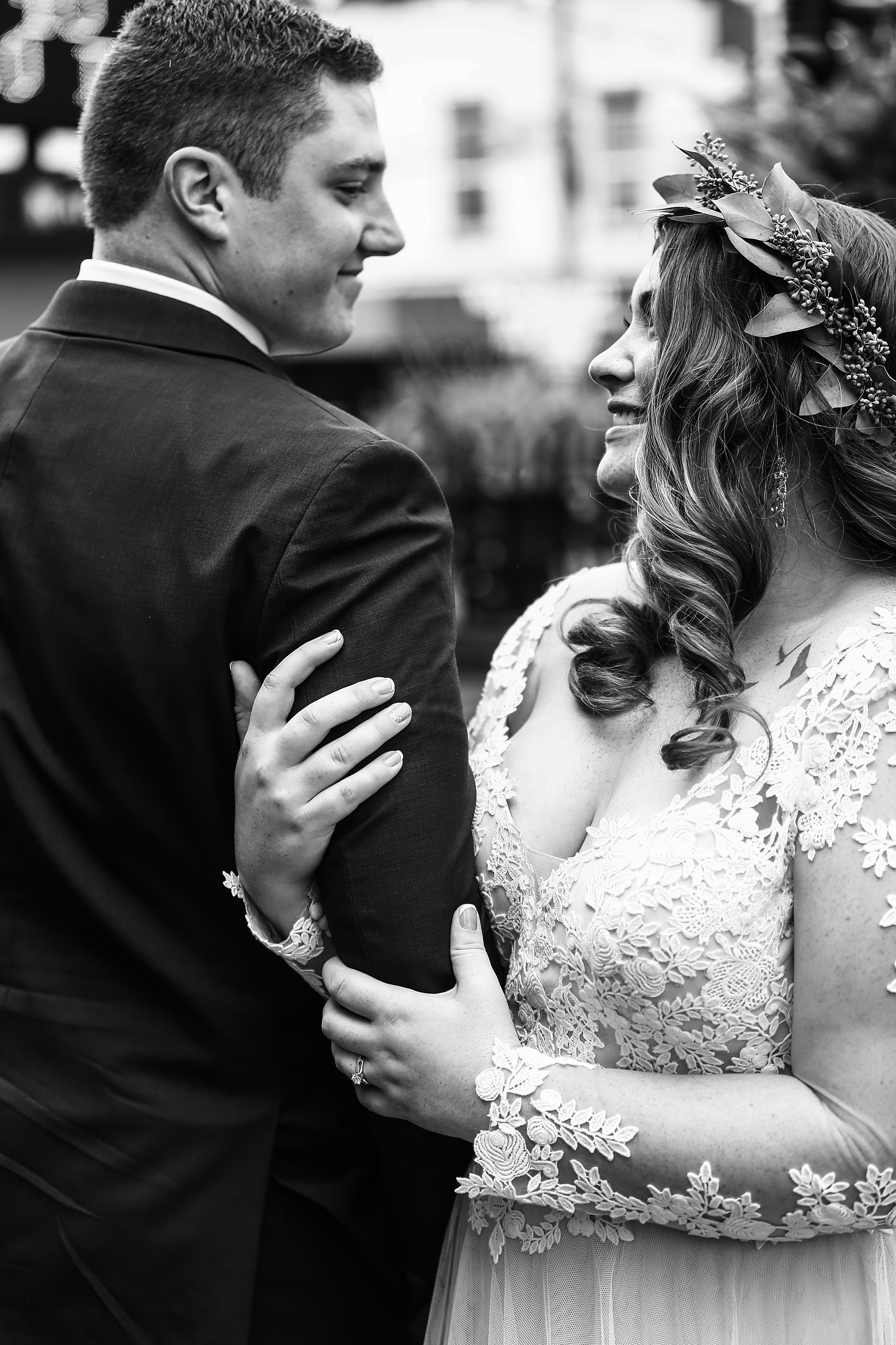 Bride embraces groom's arm outside the Waterford Hotel