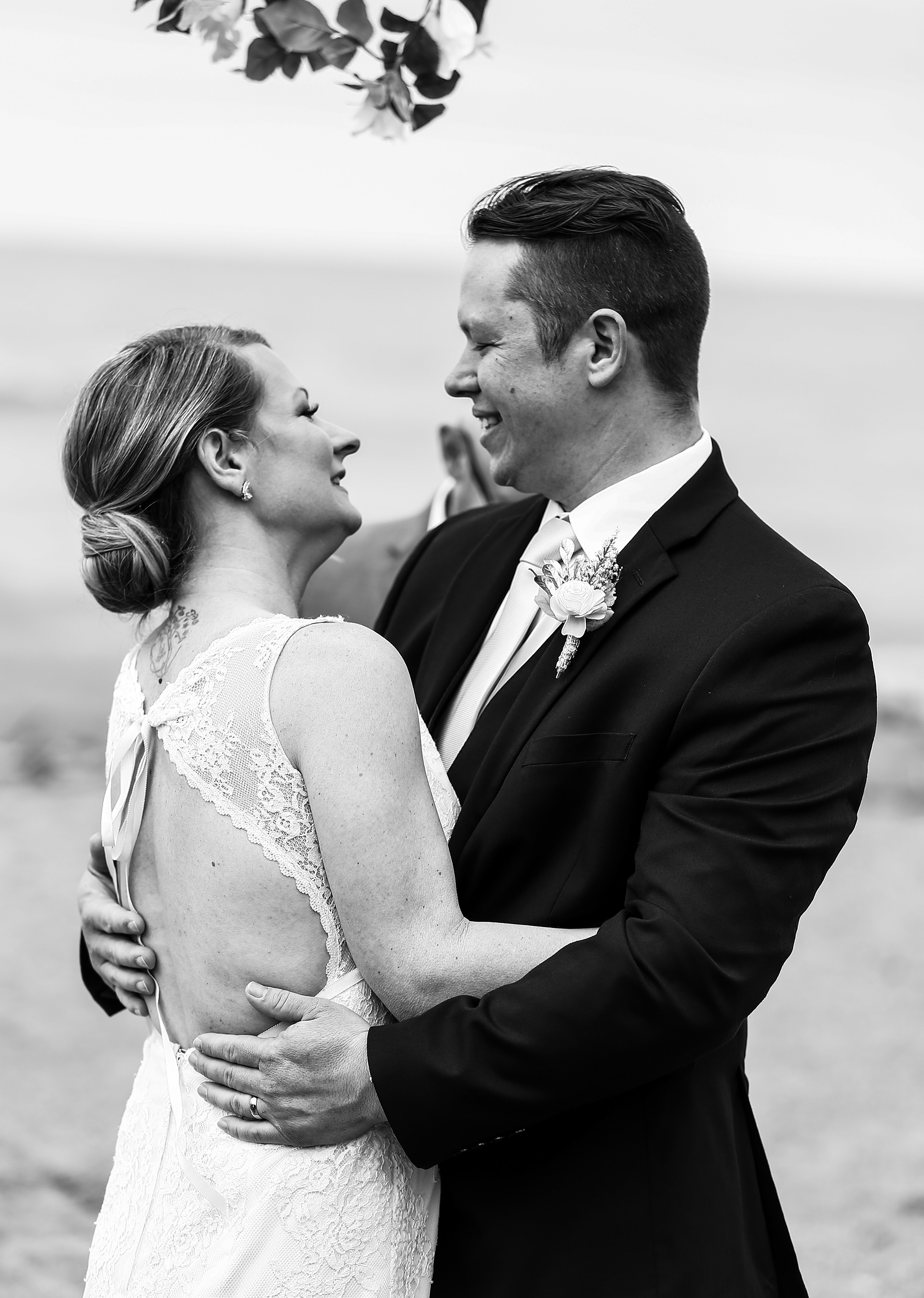 Bride and groom embrace at their Presque Isle beach wedding