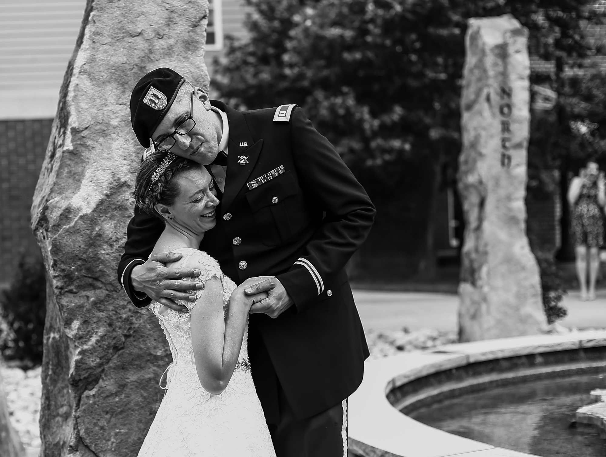 Bride and groom embrace next to Standing Stones at their wedding at Edinboro University