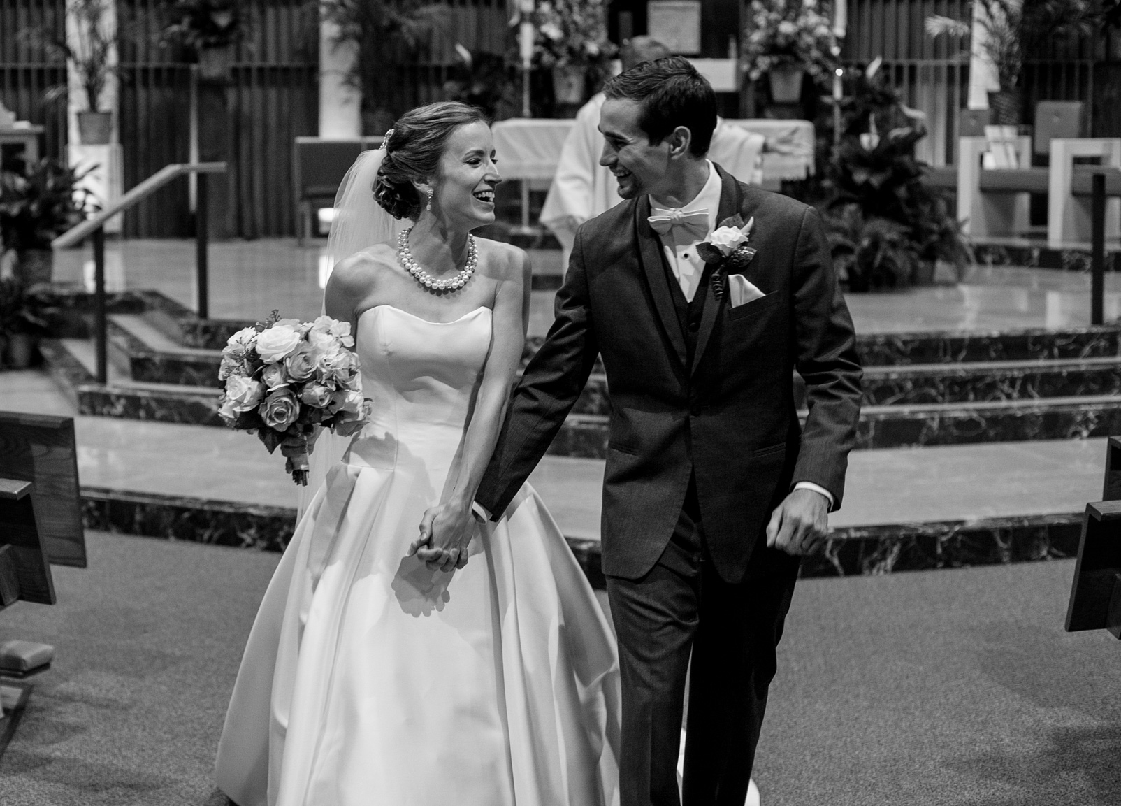 Recessional portrait of bride and groom after their wedding at St. Jude Church in Erie, PA