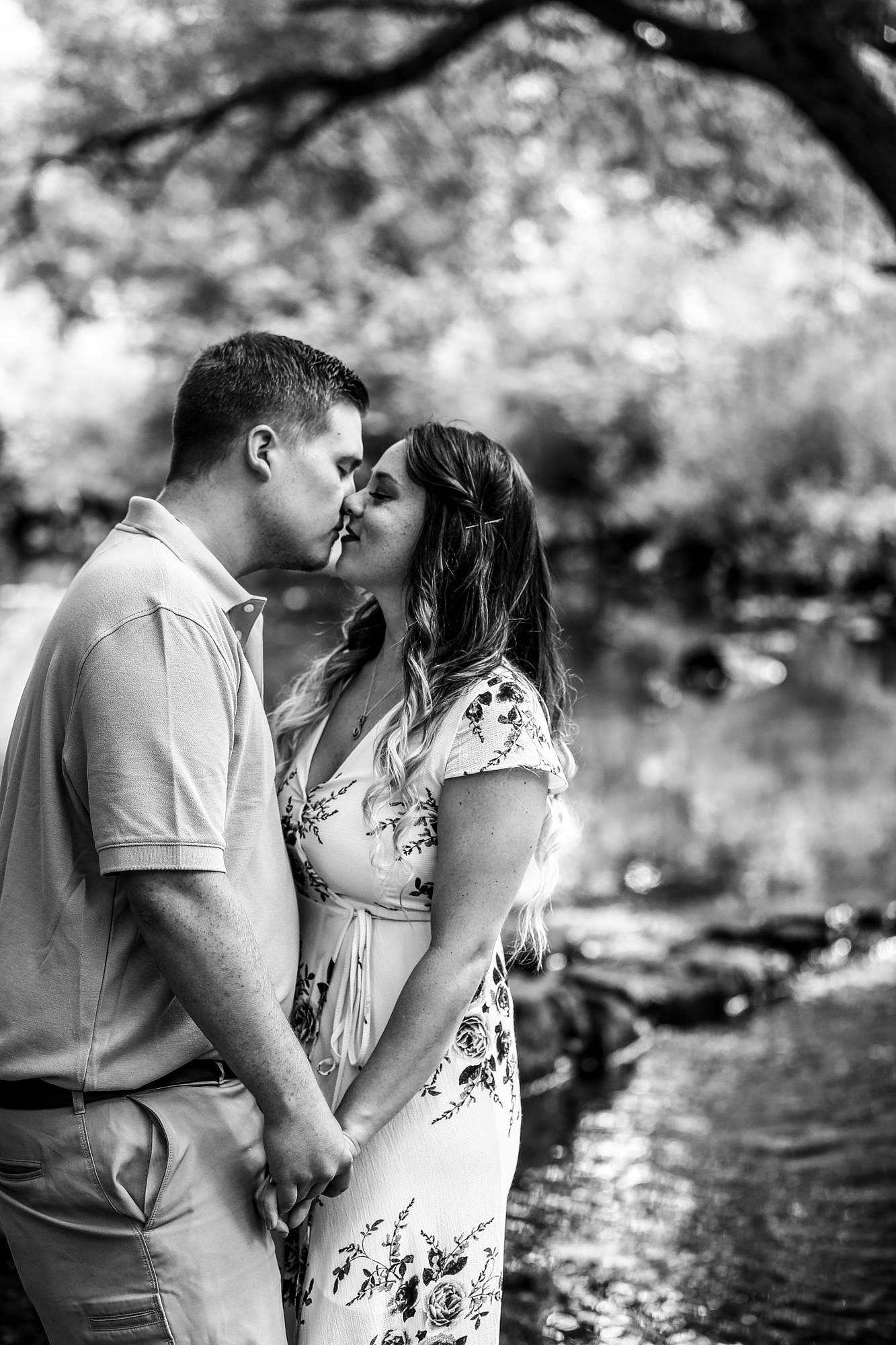 Couple holding hands about to kiss during summer engagement photos at Frontier Park