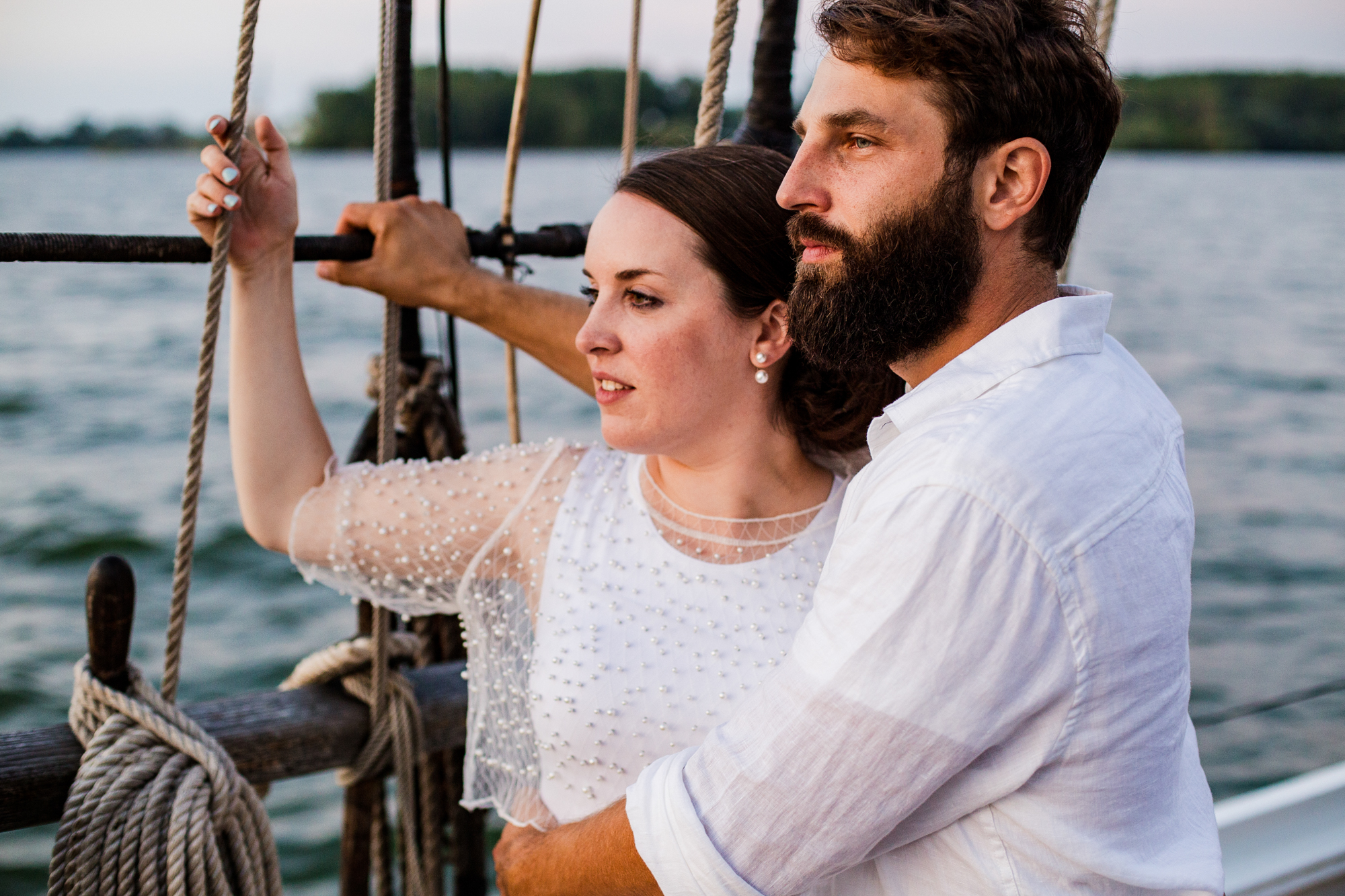 Bride and groom admire the horizon from the deck of the Lettie G Howard