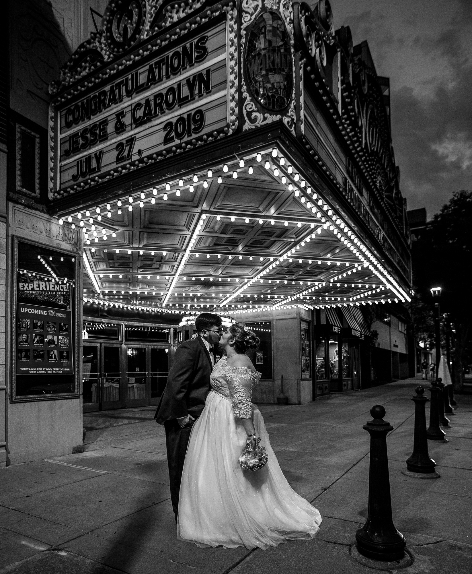 Bride and groom kiss under the marquee at the Warner Theatre