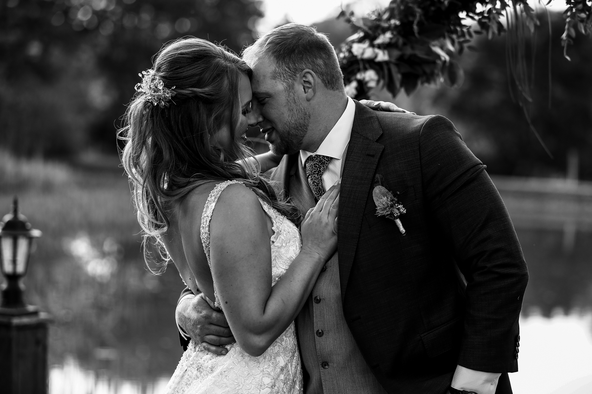 Bride and groom embrace on the dock at Rustic Acres wedding