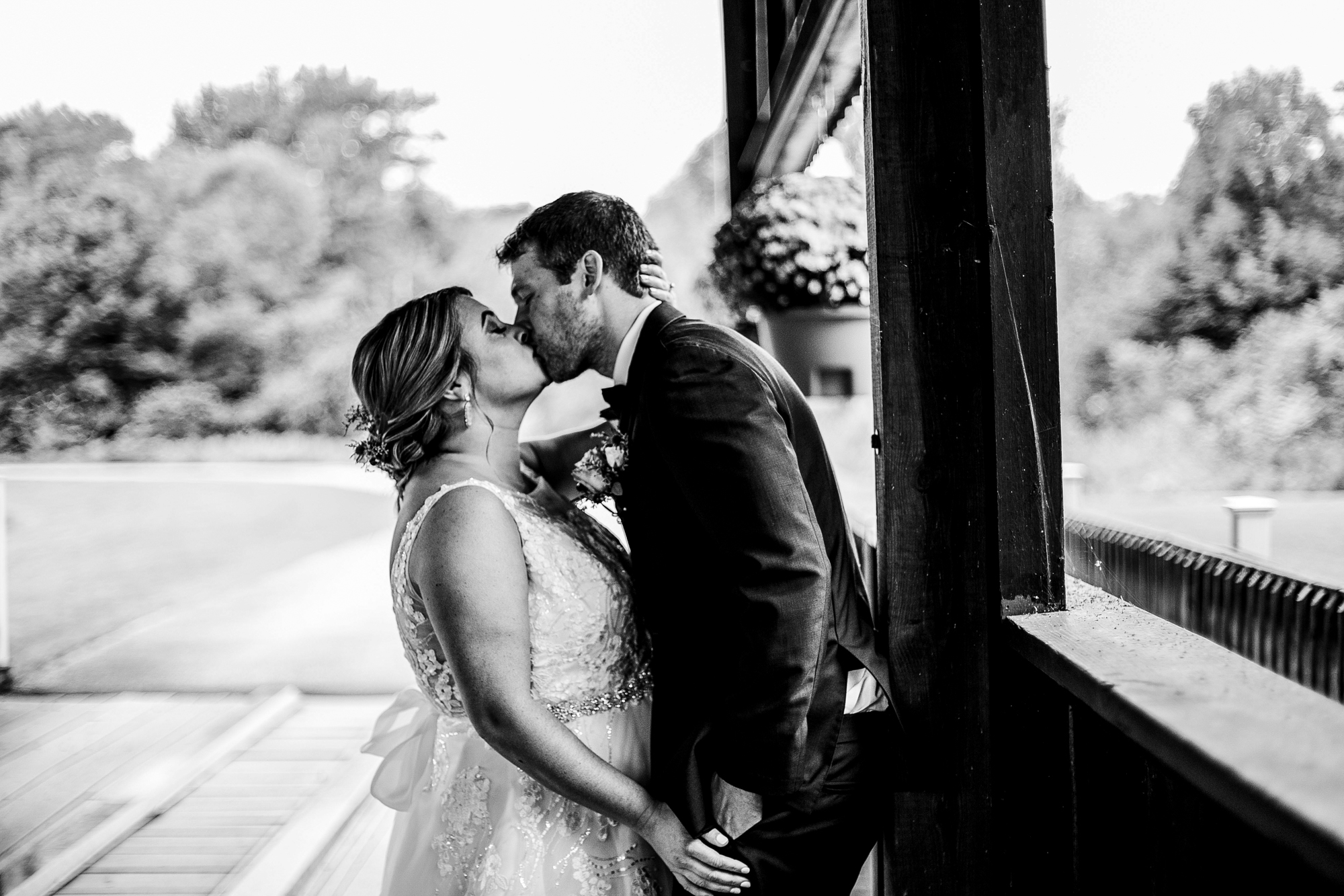 Bride and groom kissing under covered bridge at Majestic Woods