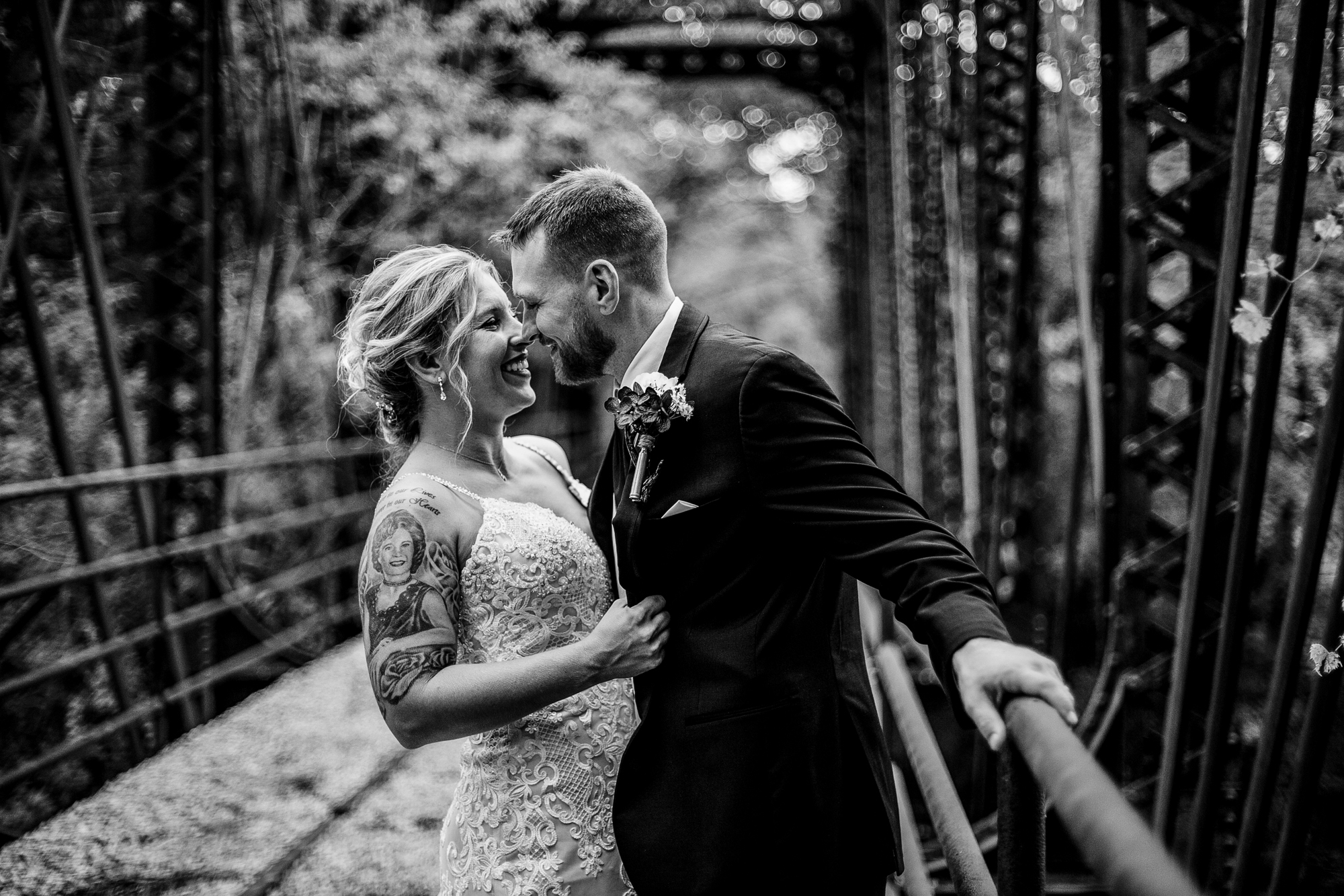 Bride and groom laughing on the railroad trestle at Barn at Conneaut Creek wedding