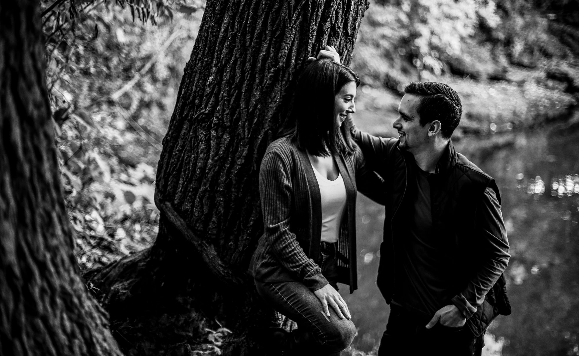 Engaged couple in Erie, PA smile at each other engagement photos at Frontier Park