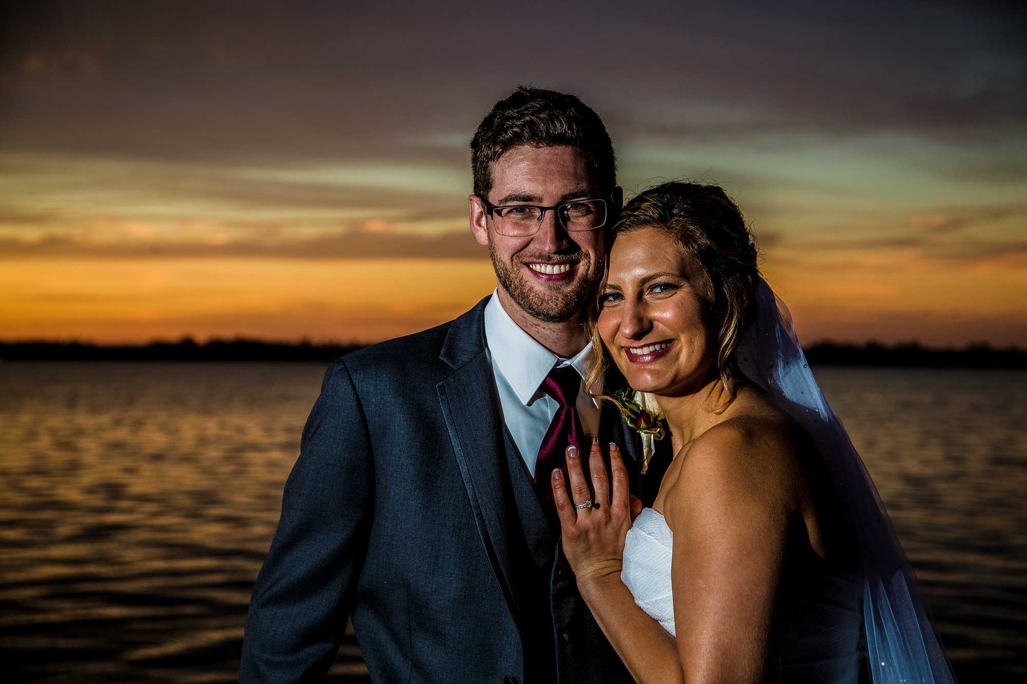 Bride and groom smiling at sunset on Lake Erie