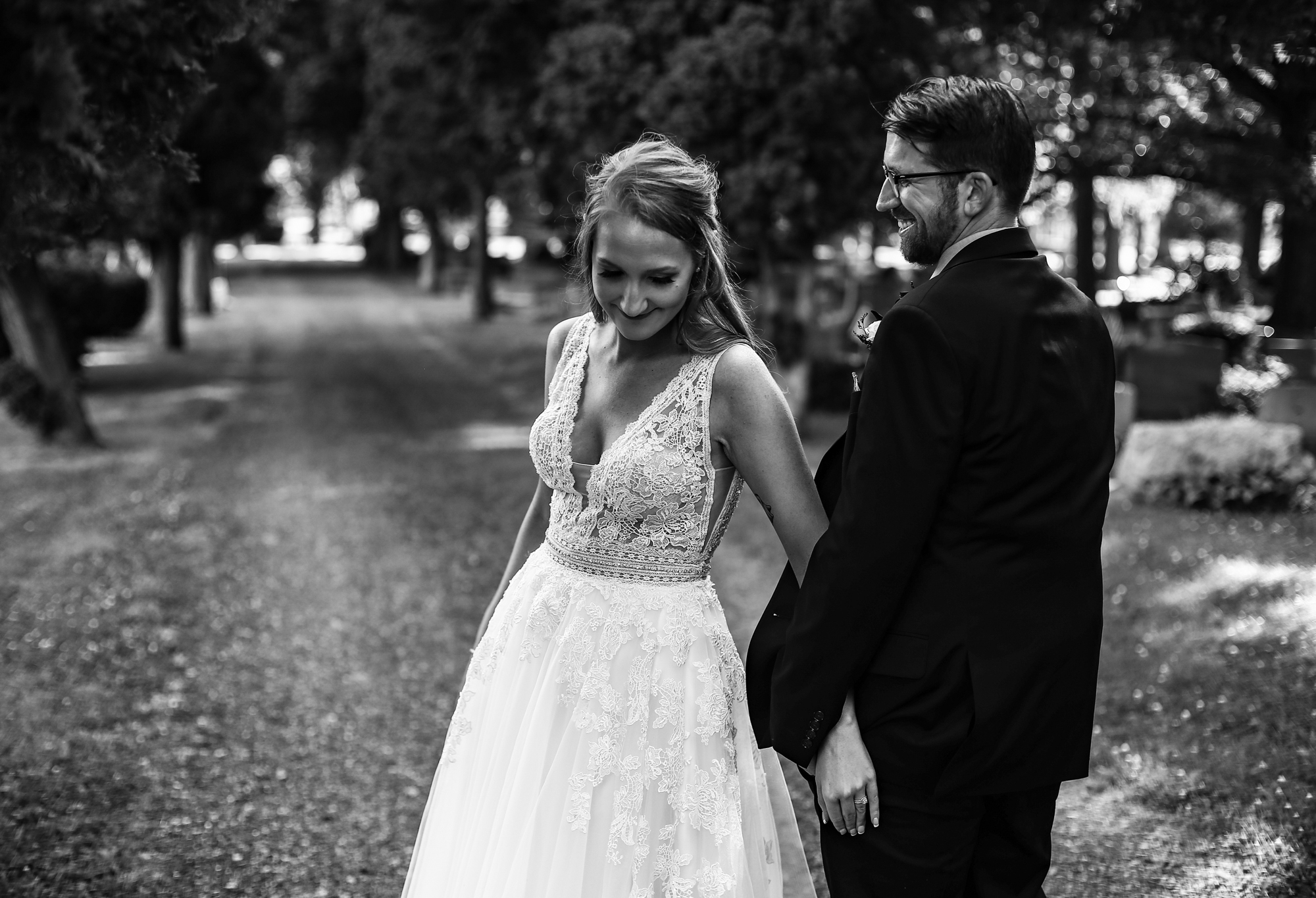 Groom smiles at his bride as they stroll together