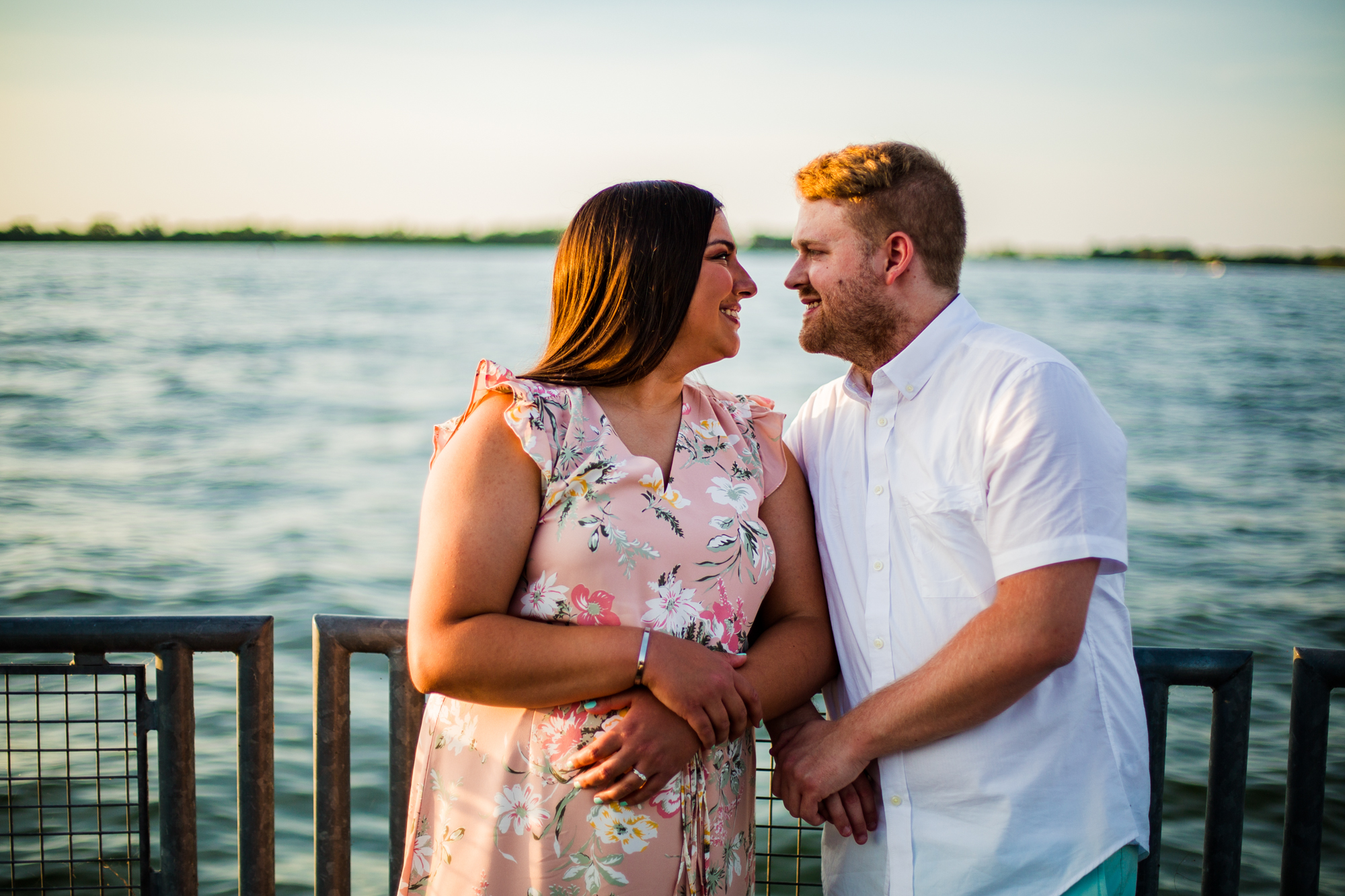 Couple smiles at each other during Erie Bayfront engagement photos