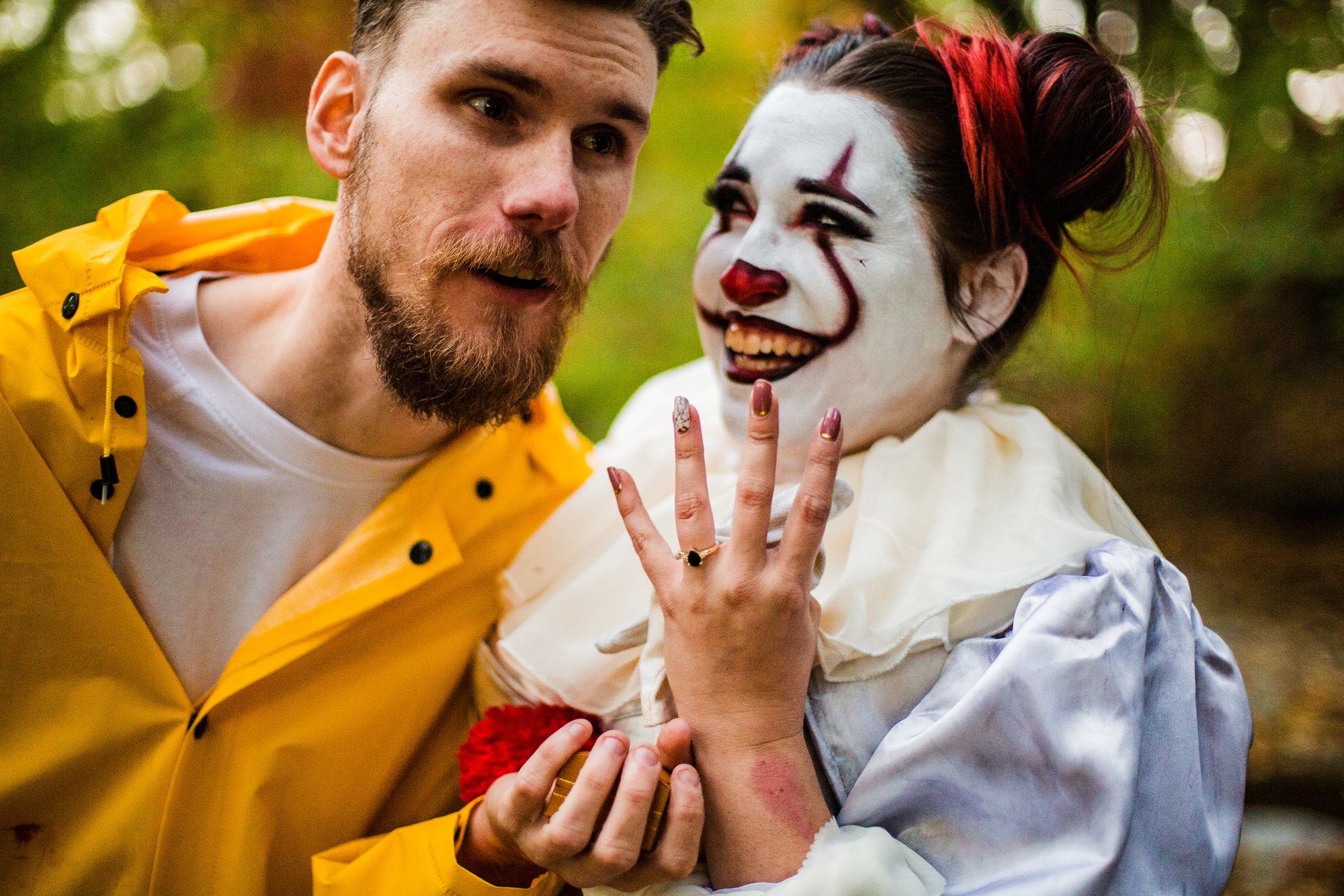 Couple shows off engagement ring at the end of Halloween engagement photo session