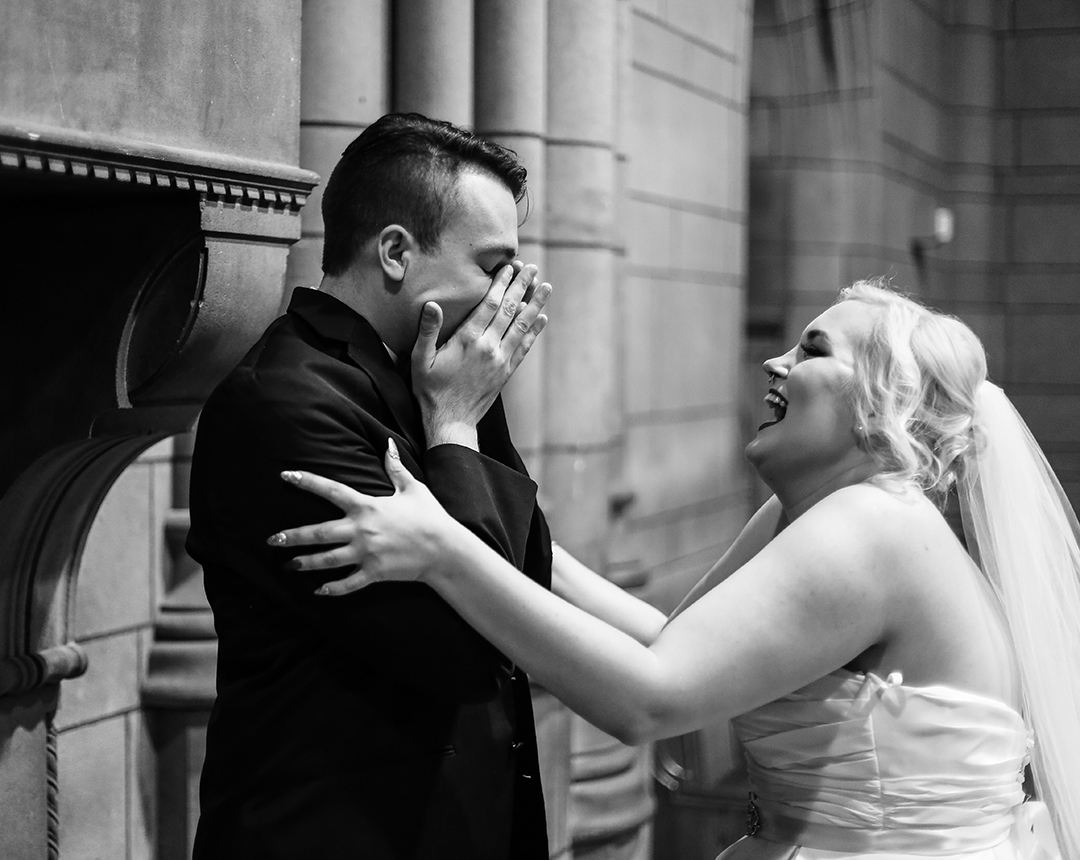 Groom covers his face in joyful surprise as he sees bride during first look photos at the Cathedral of Learning in Pittsburgh, PA