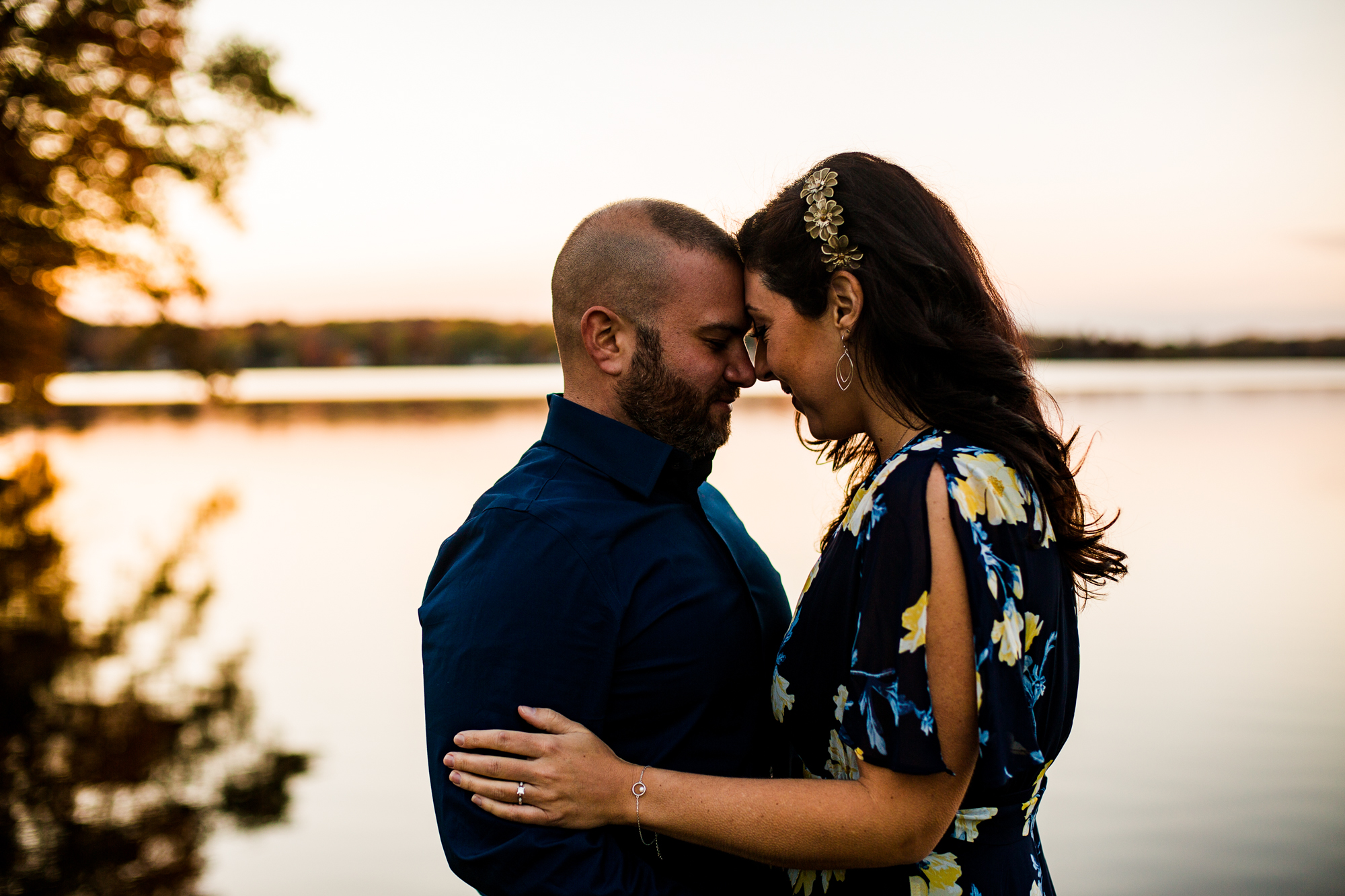 Engaged couple touch foreheads and embrace next to the lake for Edinboro PA engagement photos