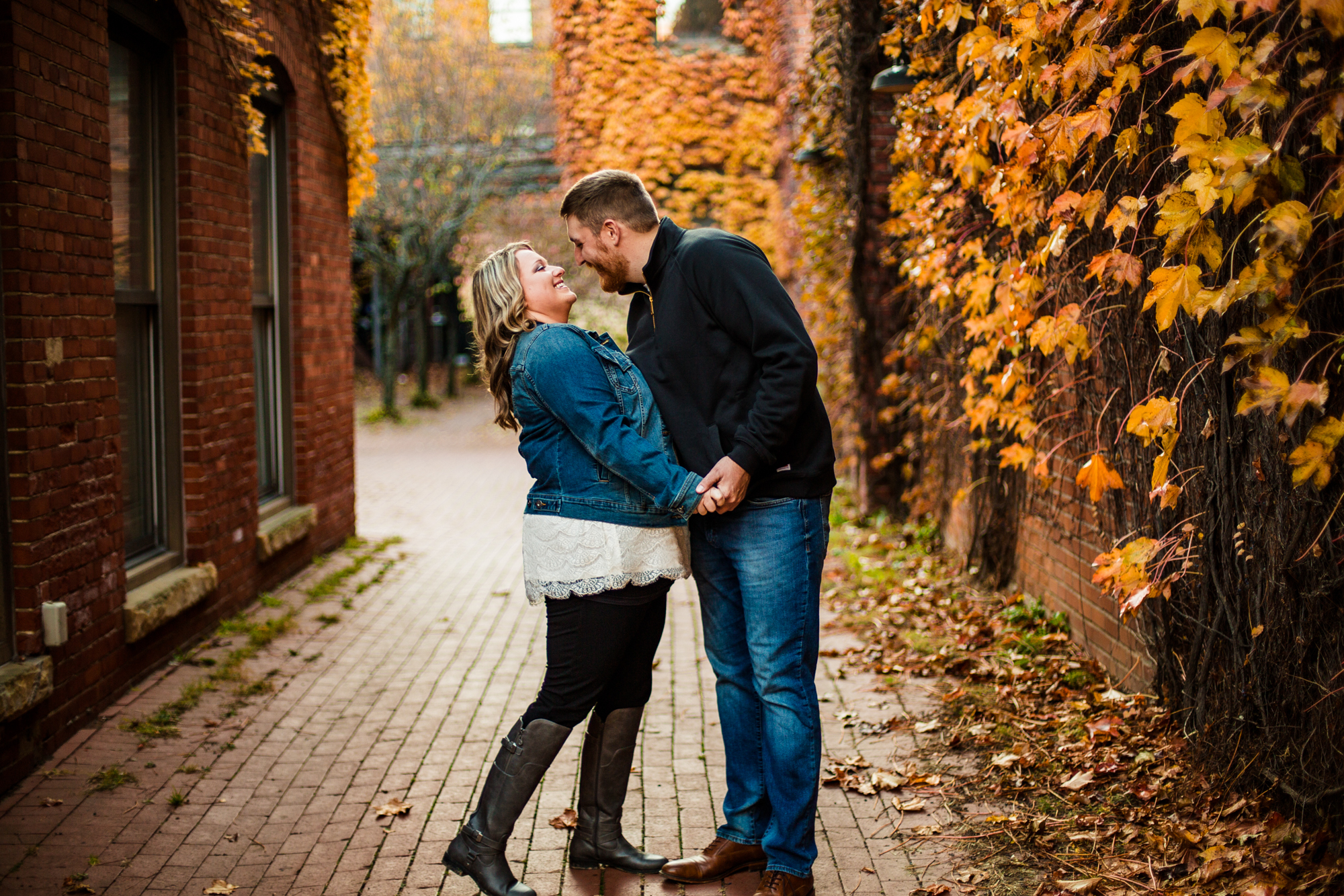Couple laughing together as man leans in to kiss woman during Modern Tool Square engagement photos