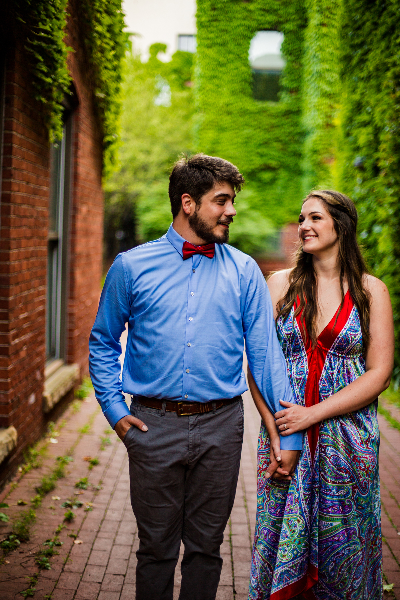 Couple holding hands while walking through Modern Tool Square for their engagement photos in Erie PA