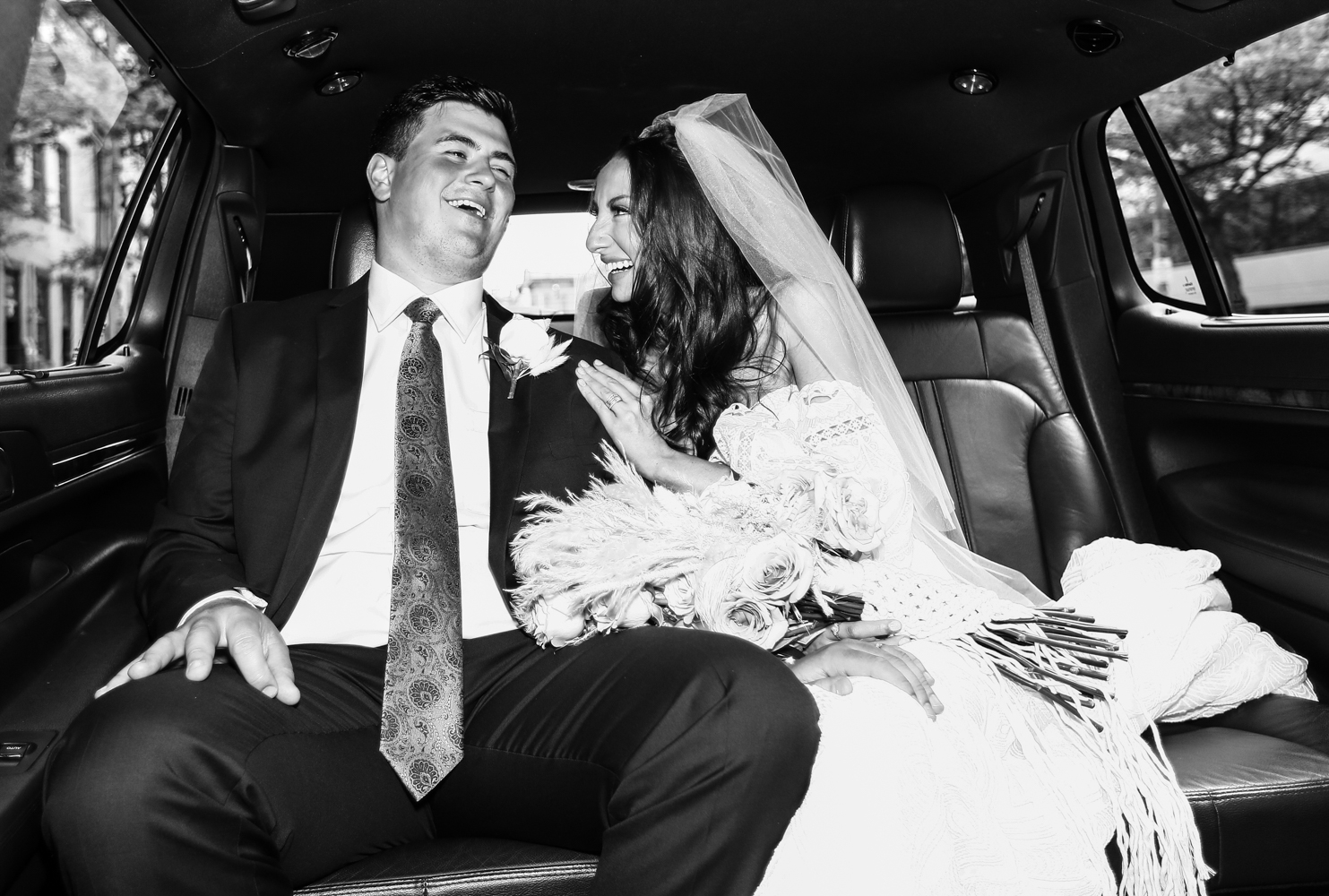 Laughing bride and groom in limo on their way to wedding reception in Erie,PA