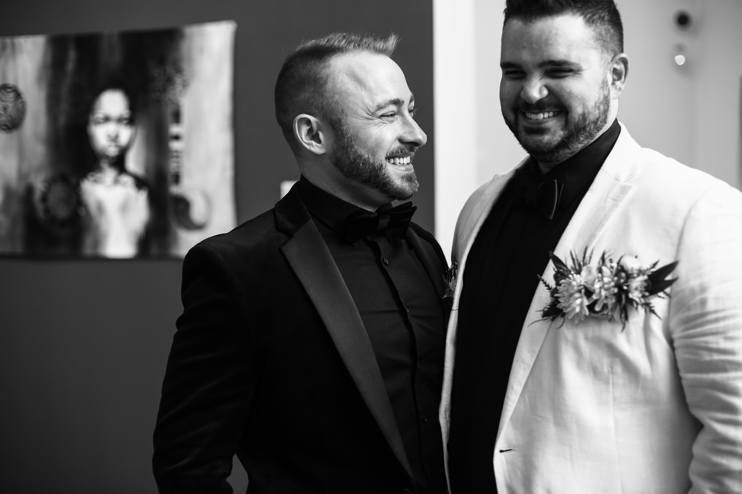 Smiling grooms in gallery at Erie Art Museum wedding