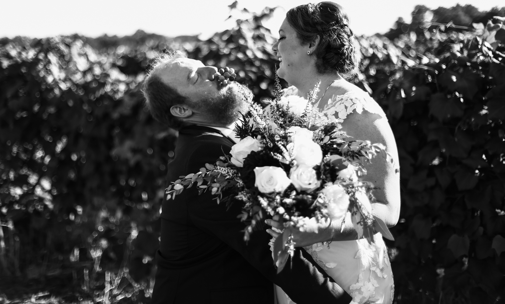 Bride feeds grapes to her groom at Lakeshore Vineyard wedding